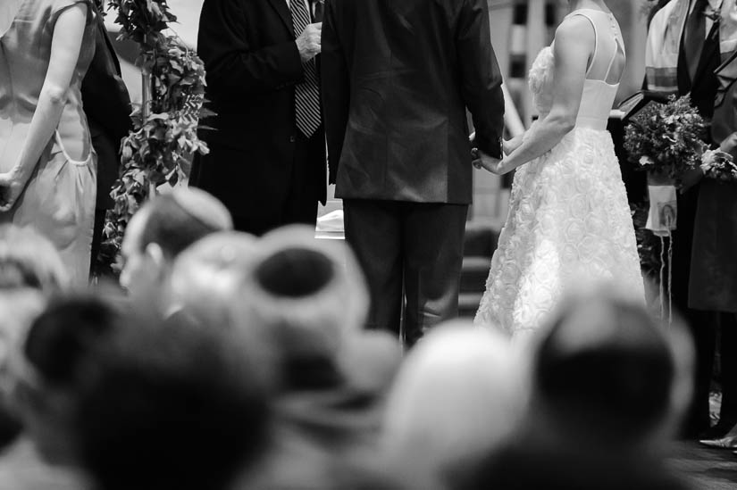 bride and groom holding hands during jewish wedding ceremony