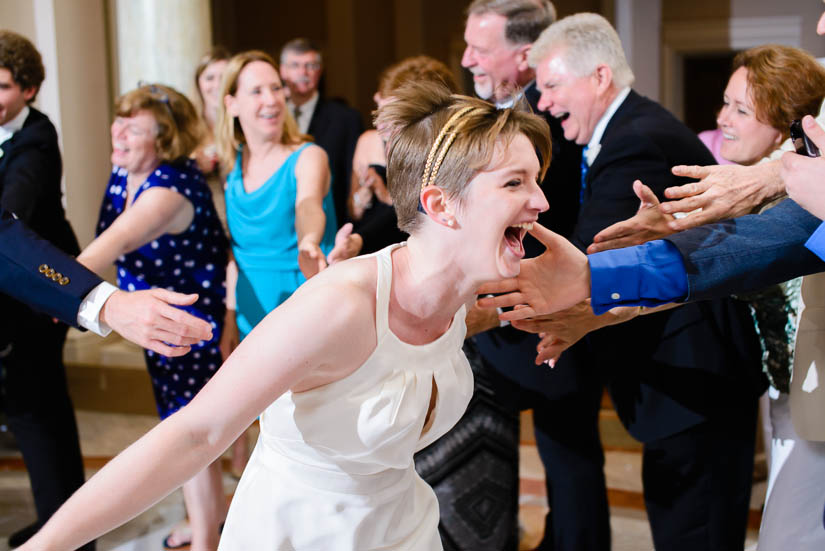 bride running through a circle of high fives