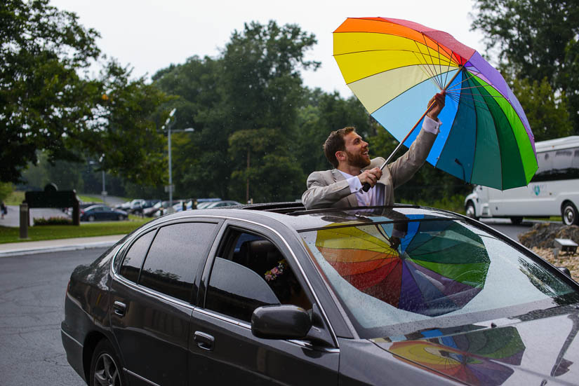 groom with rainbow umbrella at the woodlands at algonkian