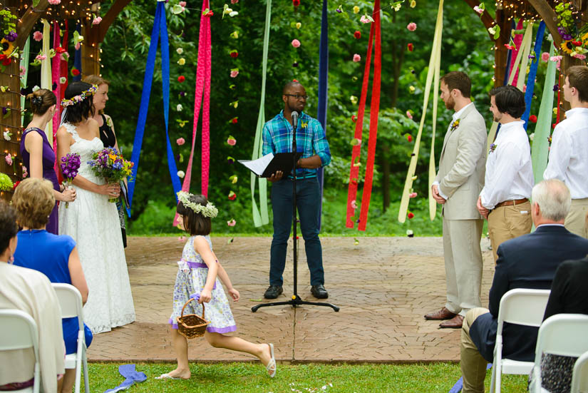 flower girl running in front of the ceremony at the woodlands at algonkian wedding