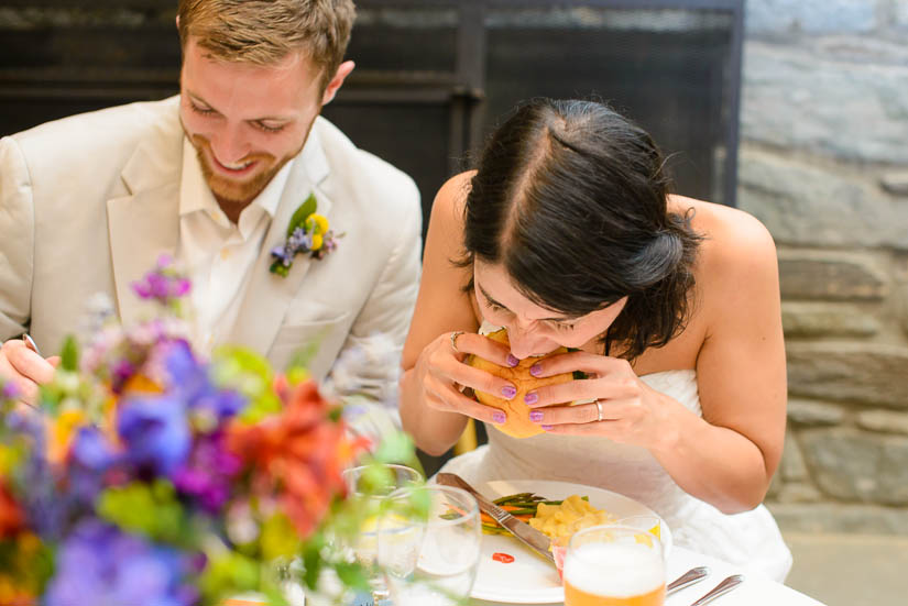 bride chowing down on a burger at the woodlands at algonkian wedding